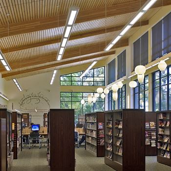 a view of the library with windows and wood ceilings